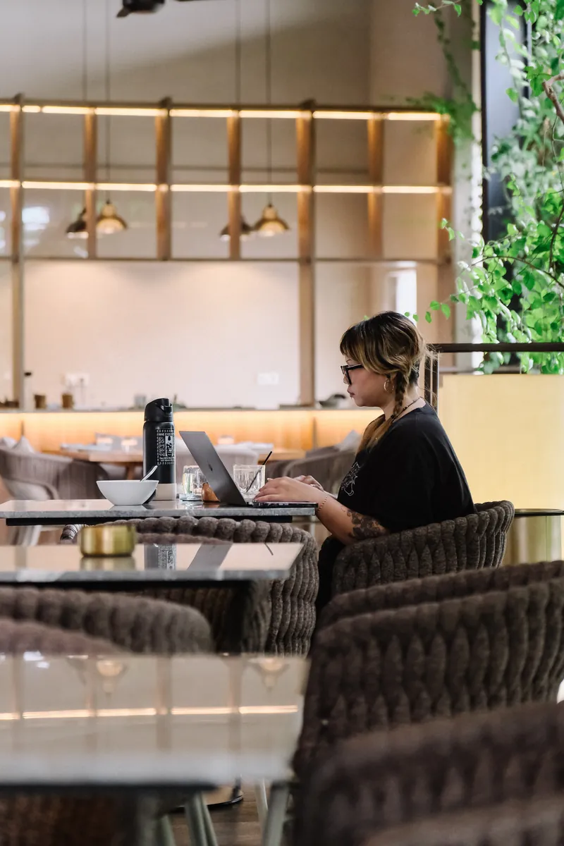 A guest working on a laptop in the cafe