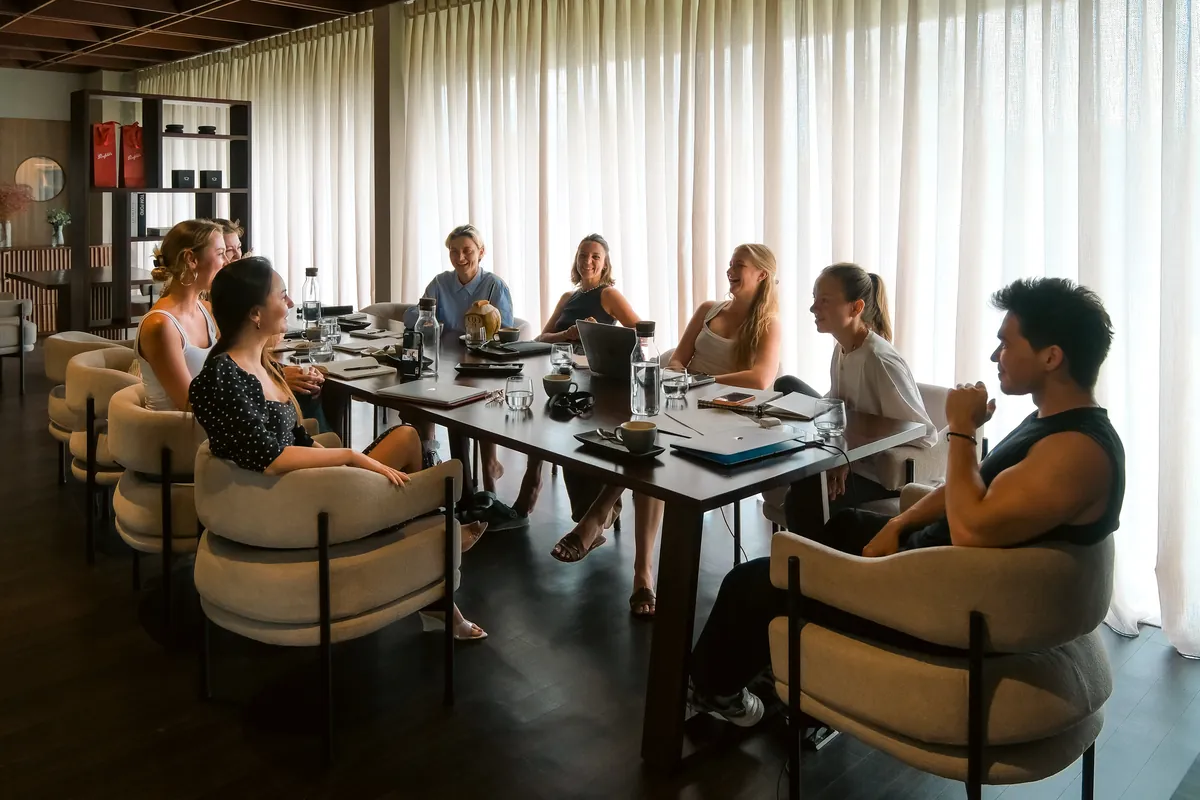 A group meeting around the long table in The Lounge