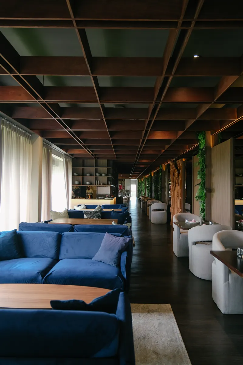 Blue velvet sofas under the timber ceiling