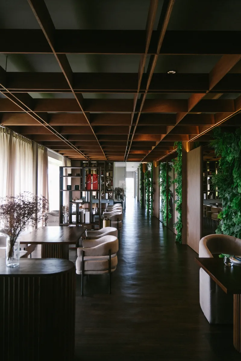 The long upstairs floor with plants and timber ceiling