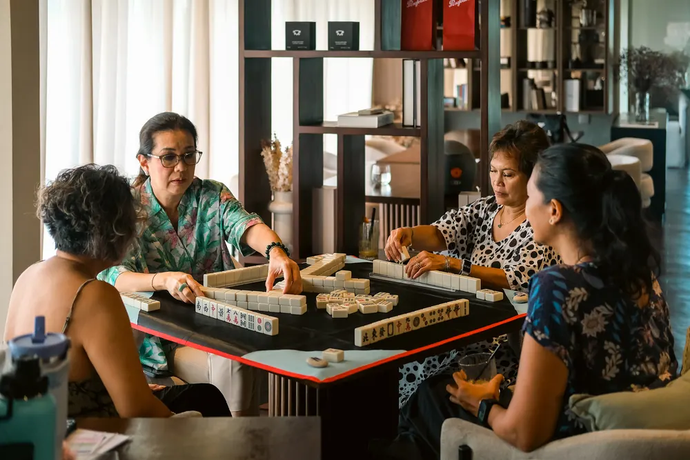 Friends playing mahjong in The Lounge
